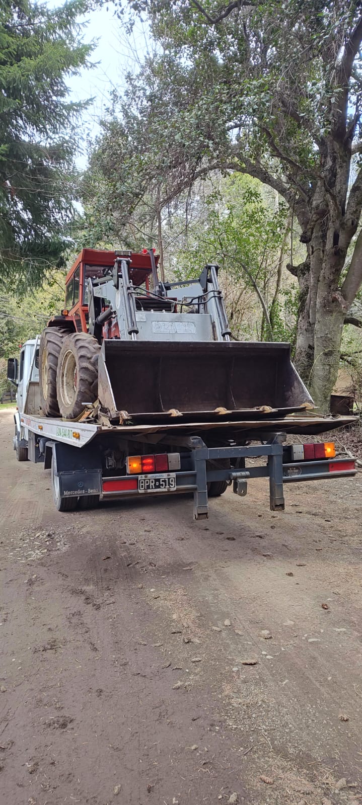Unidad de Volk Auxilios trasladando un tractor por camino de ripio